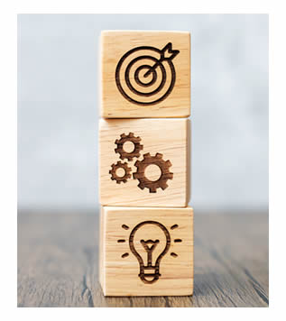 http://Bloques%20de%20madera%20con%20símbolos%20de%20objetivos,%20engranajes%20e%20ideas%20que%20representan%20la%20planificación%20estratégica.